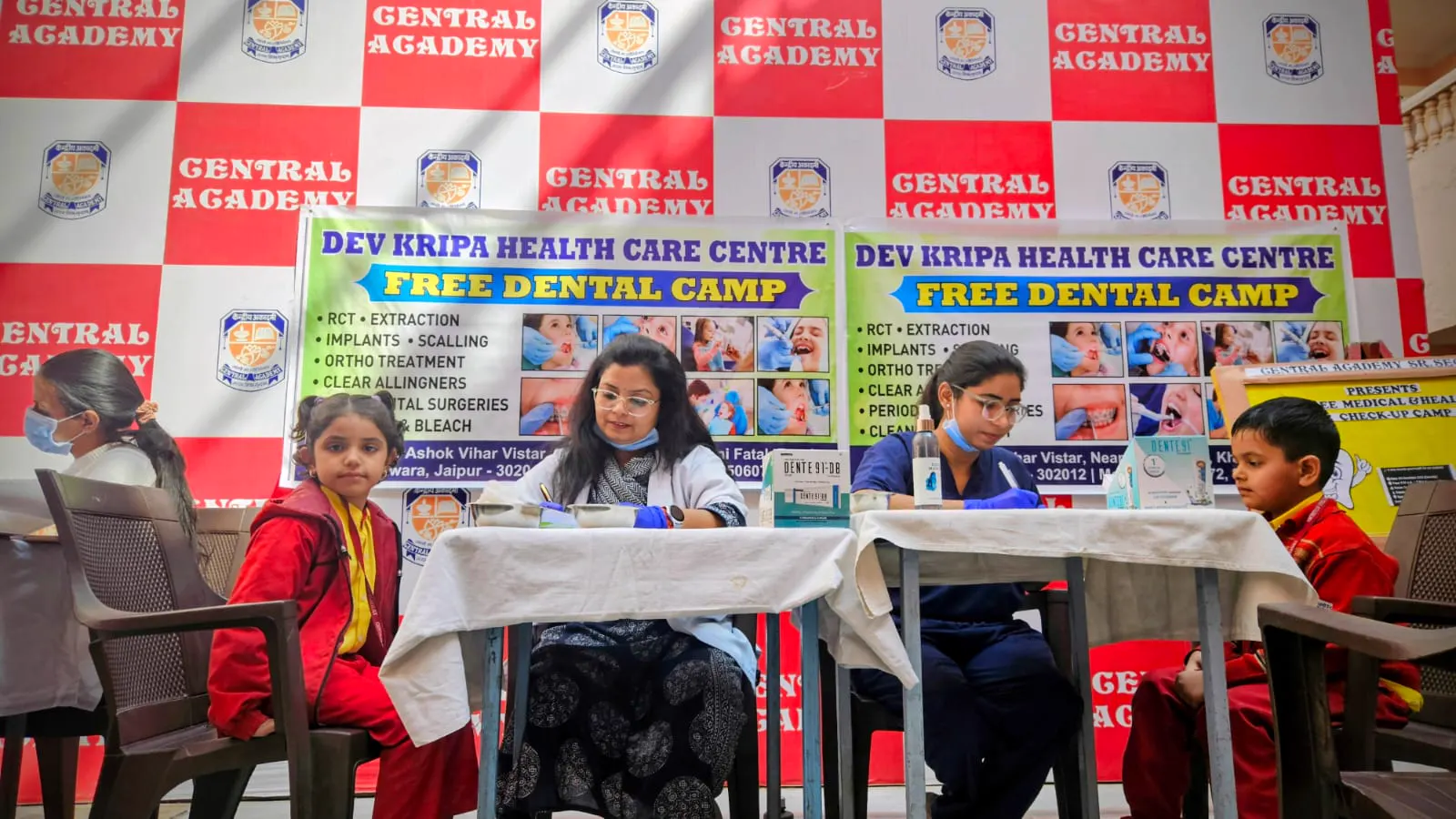 Dr. Jahanvi Tyagi and a team dentist checking schoolchildren's teeth at a free dental camp