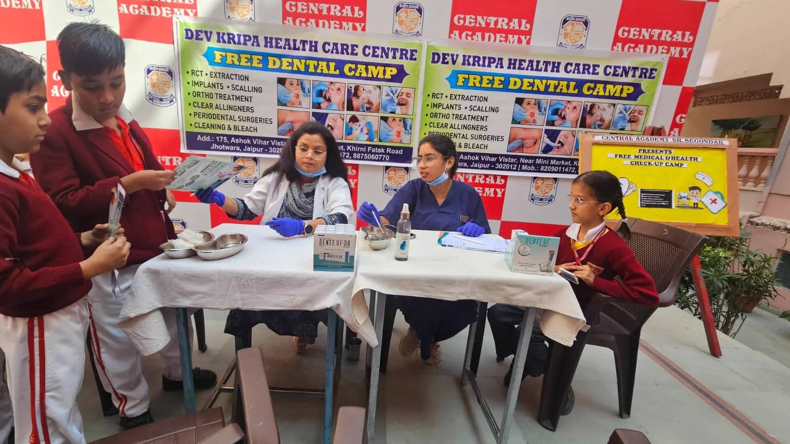 Clinic dentists examining students at the camp tables