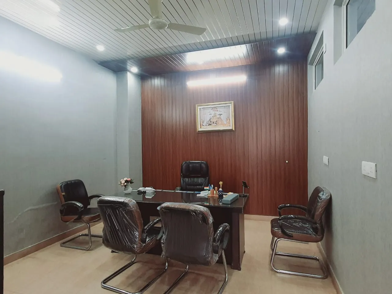 Consultation room with wood-panelled wall and desk