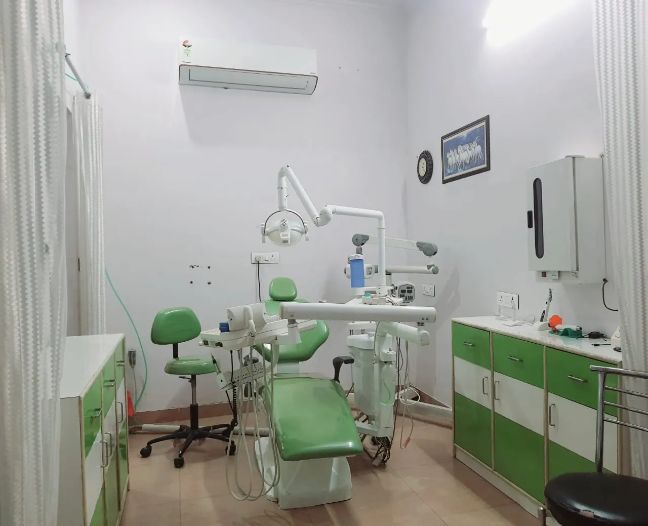 Dental operatory with a green dental chair and cabinets
