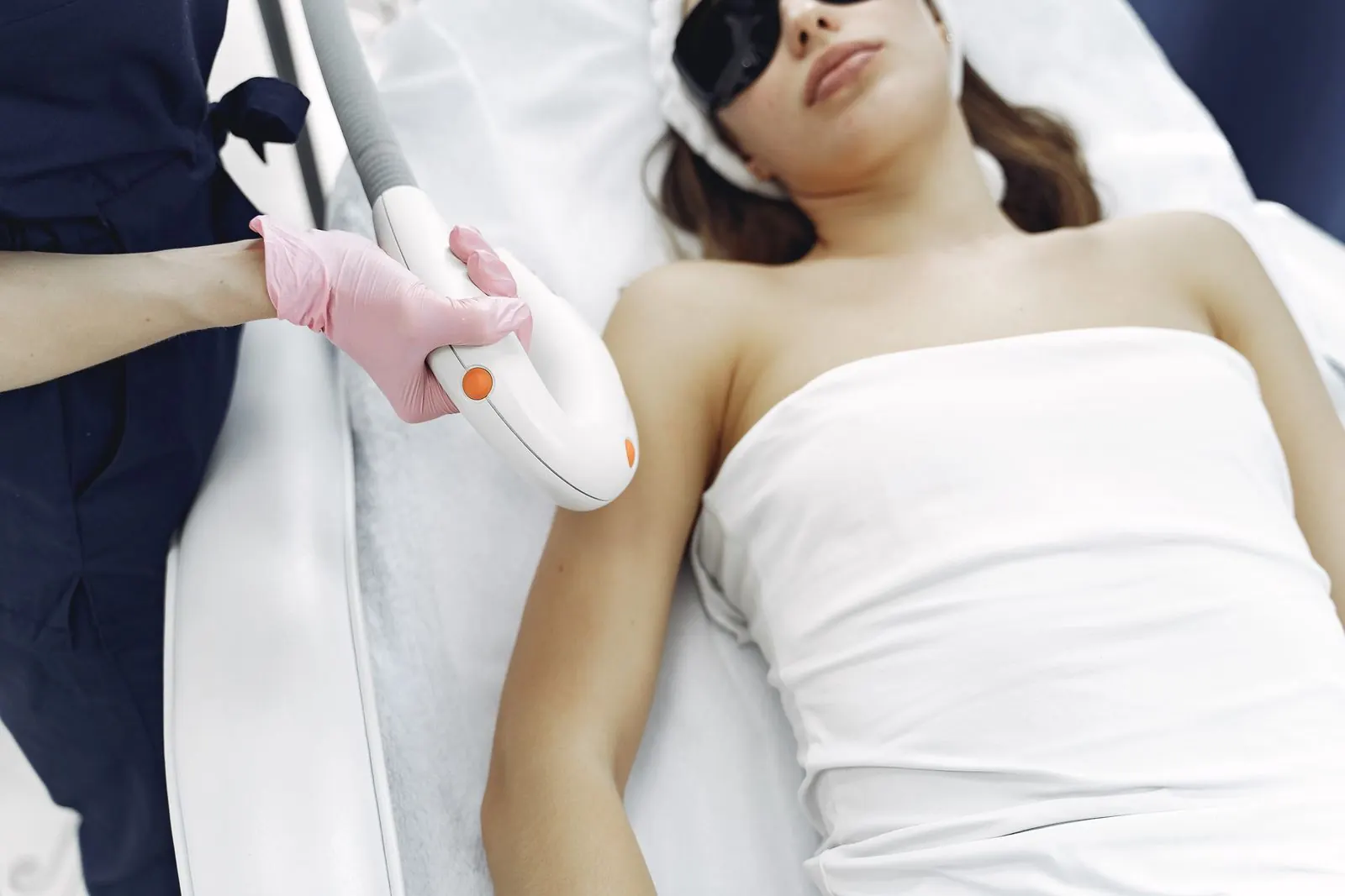 A laser hair removal session on a patient wearing safety glasses